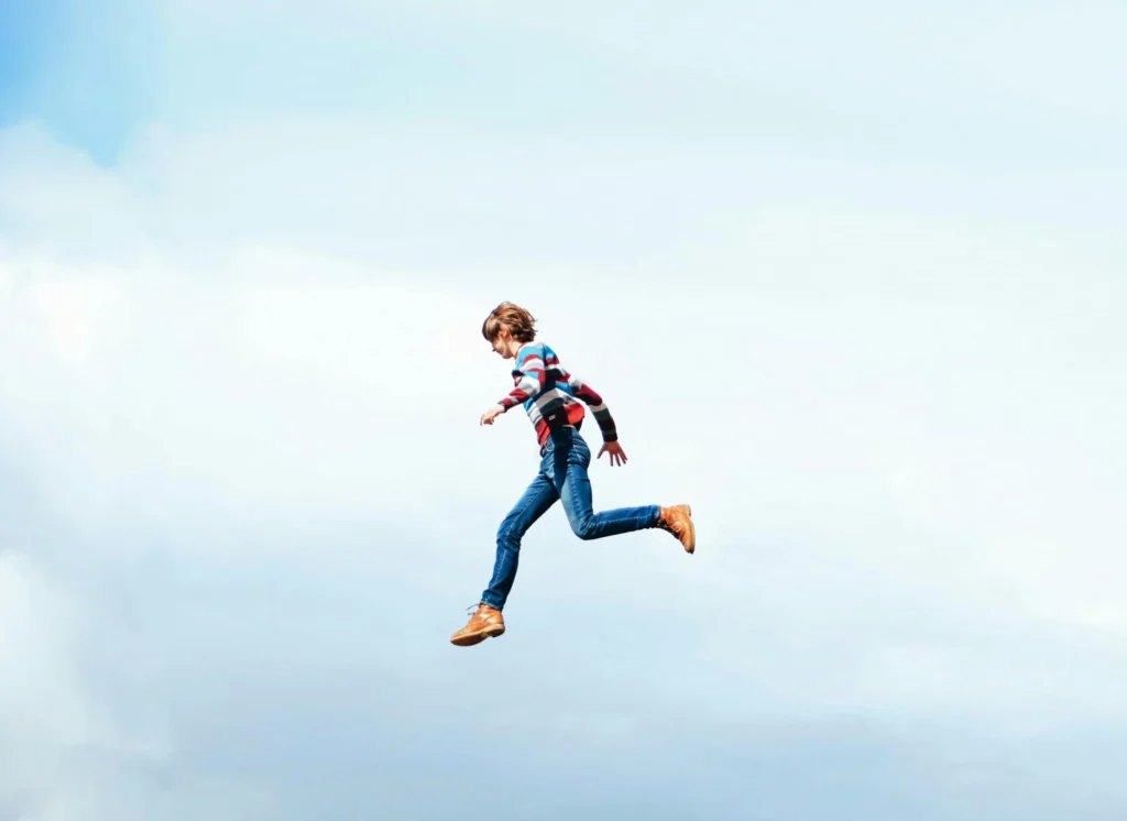 Un adolescent courant dans un ciel bleu, illustrant la liberté et la recherche de nouvelles opportunités professionnelles.