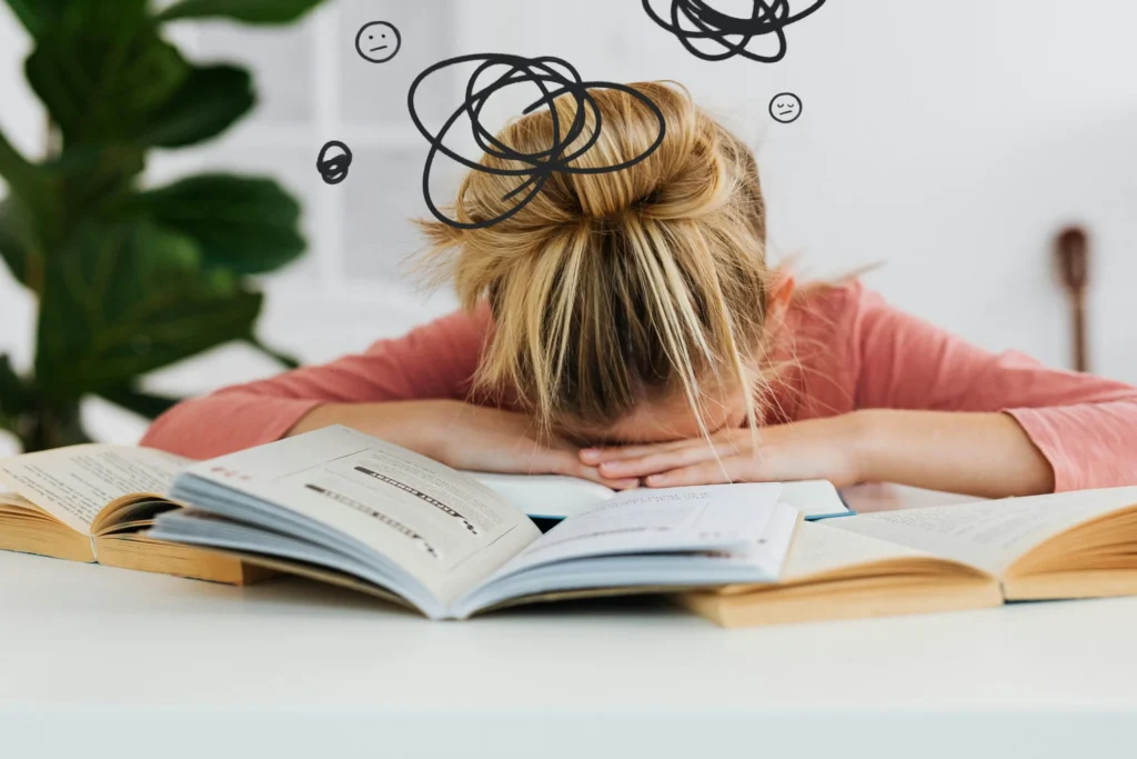 Enfant tête posée sur ses mains en difficulté scolaire fatigué face à ses devoirs et apprentissage.