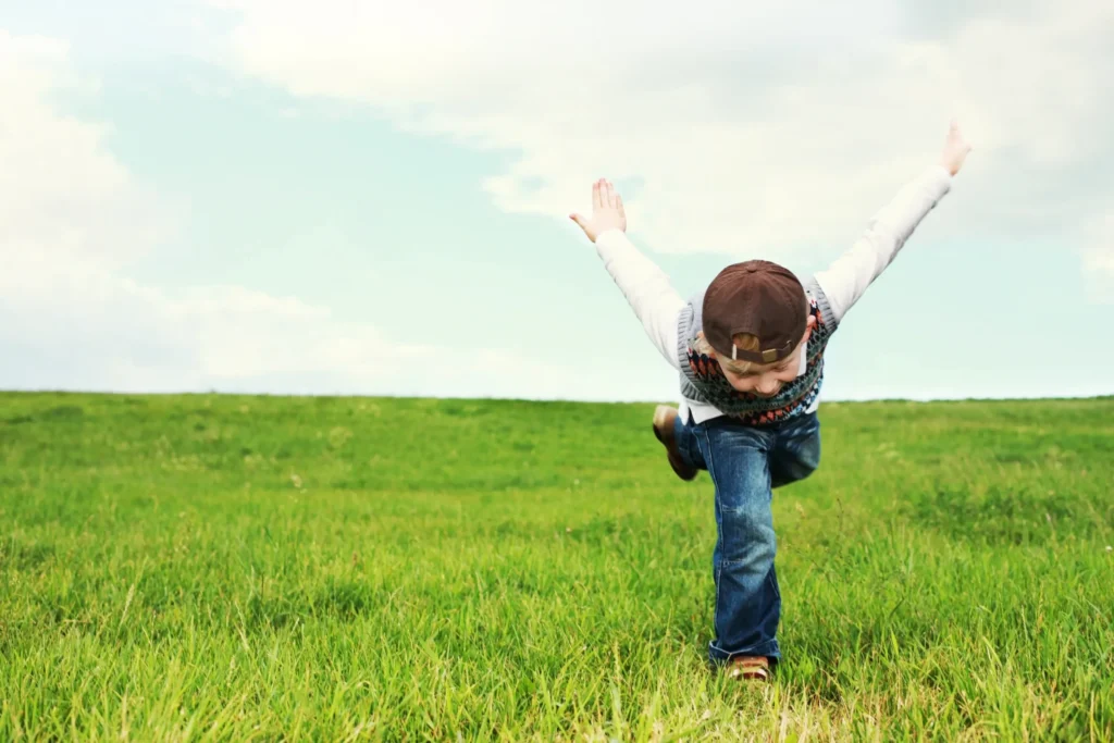 Enfant épanoui jouant dehors dans un contexte d’apprentissage positif.