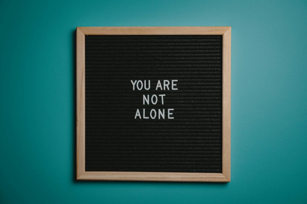 Tableau avec le message 'YOU ARE NOT ALONE', symbolisant le soutien et l'accompagnement pour les parents.